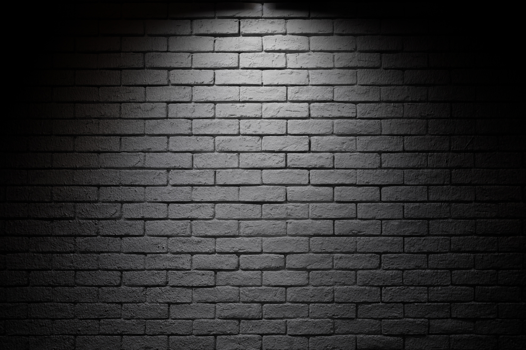 Bright spotlight illuminate dark brick wall